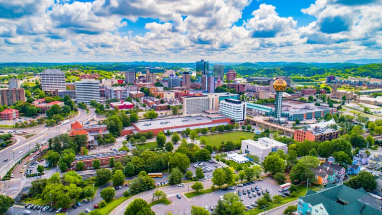 Knoxville Tennessee skyline during the day. Clouds in the sky and green hills in the background