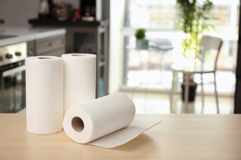 Three rolls of paper towels on a kitchen counter